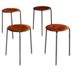 three wooden stools sitting next to each other on top of a white surface with metal legs