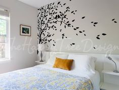 a bedroom with a bed and wall decals on the walls in black, white and yellow colors