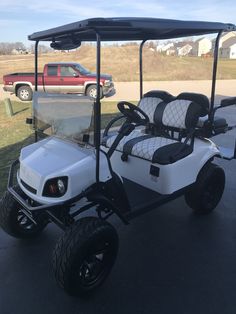 two white golf carts parked in a parking lot