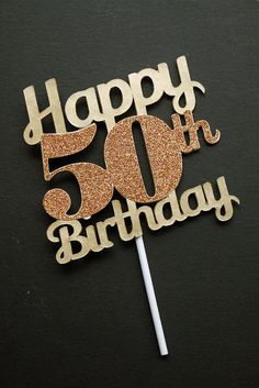 a 50th birthday cake topper with the number fifty five in gold glitter on a black background