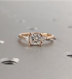 a three stone ring with two diamonds on the top and one diamond in the middle