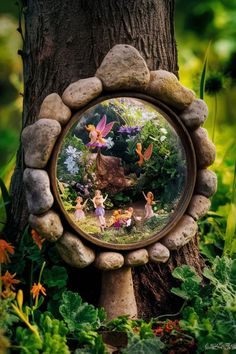 a fairy garden scene is seen through a mirror on a tree in the grass with flowers and plants around it