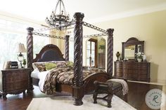 a bedroom with four poster bed, dresser and mirror