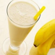 a banana sitting next to a glass filled with milk