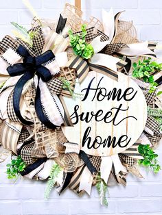 a wreath with the words home sweet home written in black and white letters on it