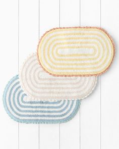 three round rugs on top of each other in different colors and sizes, one is yellow, the other blue