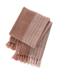 the brown and white checkered blanket is folded on top of each other with fringes