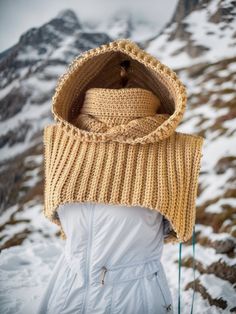 a woman wearing a knitted hat in the snow with her back turned to the camera