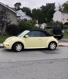 a small yellow car parked in a parking lot