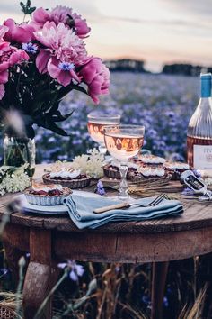 the table is set with flowers and wine for two people to enjoy in the evening