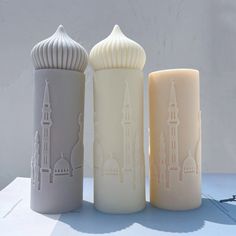 three different colored candles sitting next to each other