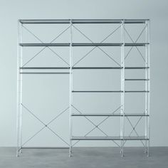 an empty metal shelf with four shelves on each side and one in the middle, against a white wall