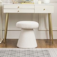 a white stool sitting under a mirror on top of a table