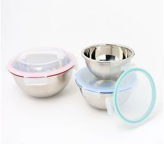 three stainless steel bowls with lids on each one and a magnifying glass in the other