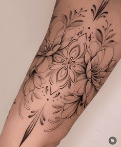 a woman's leg with flowers on it and an arrow drawn in the middle