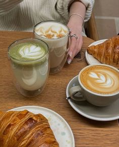 there are two croissants on the table with coffee and milkshakes