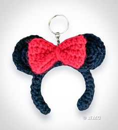 a crocheted mickey mouse ears keychain with a red bow on it