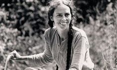 black and white photograph of a woman riding a bike