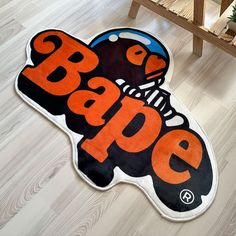 an orange and black rug with the word bape on it