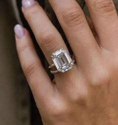 a woman's hand with an engagement ring on it and a diamond in the middle