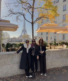 two women standing next to each other in front of the eiffel tower