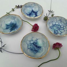 four blue and white bowls with flowers in them