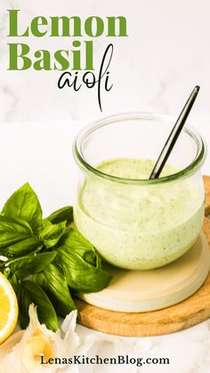 lemon basil aioli in a small glass bowl on a cutting board next to fresh basil leaves