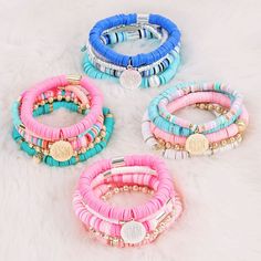 four different colored bracelets on a white fur surface