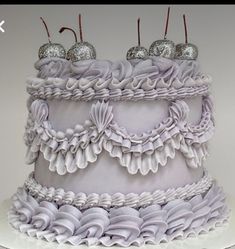 a three tiered cake with white icing and silver decorations