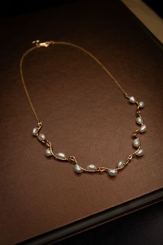 A handmade necklace with small freshwater pearls woven onto hammered gold-filled connector bars. Specifications: Length: 18 inches Materials: 18k Gold, Sterling Silver, Freshwater Pearls 90-97% Clear, High Luster/Nacre All orders come with a handwritten note, a sturdy cardboard drawer box, and a velvet pouch. Note: Each piece is hand-selected and hand-made to order. All of our natural materials vary in size and detailing, so each piece is uniquely your own. Made to order: ships within 2 to 4 wee Pearl Wire Necklace, Pearl With Gold Necklace, Edwardian Jewelry Necklaces, Jwellary Unique, Unique Pearl Necklace, Small Gold Necklace, Vine Necklace, Pearl Gold Necklace, Gold And Pearls