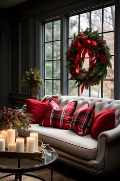 a living room decorated for christmas with candles and wreaths on the window sill