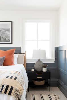 a bedroom with a bed, nightstand and pictures on the wall