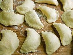 some dumplings are sitting on a cutting board with flour sprinkled around them