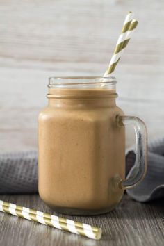 a smoothie in a mason jar with two straws