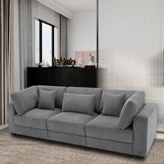 a living room with a gray couch and large windows