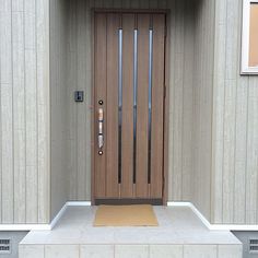 the front door to a building with a mat on the floor