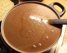 a pot filled with brown liquid sitting on top of a stove