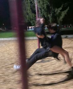 two people are playing on a swing set