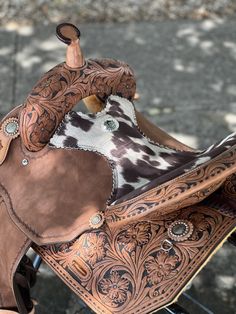 a brown and white cow print saddle sitting on top of a bike