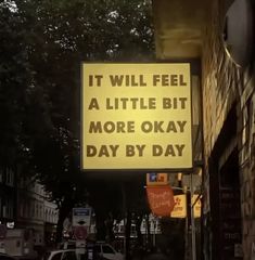 a yellow sign that says it will feel a little bit more okay day by day