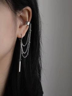 a close up of a person wearing some kind of earring with chains attached to it