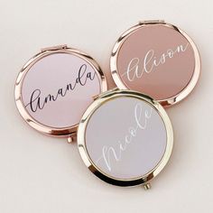 three personalized compact mirrors with names on them, one is pink and the other is white