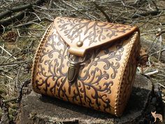 a brown leather bag sitting on top of a tree stump