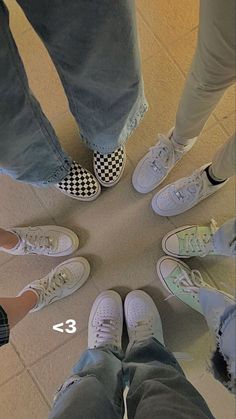 four people standing in a circle with their feet on the ground and one person wearing white sneakers