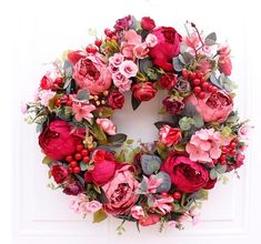 a wreath with red and pink flowers on it