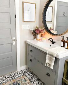 a bathroom with a sink, mirror and rug