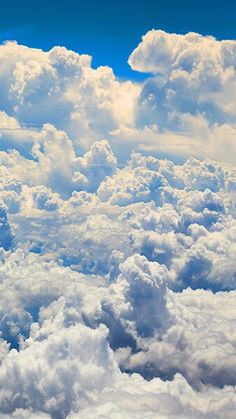 the view from an airplane window shows clouds and bright blue sky in the foreground