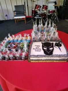 a birthday cake sitting on top of a table next to other cakes and candy bars