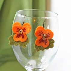 Pansies are such adorable flowers, I couldn't resist making these little felt earring versions! These orange pansy earrings are hand cut from felt and then hand embroidered. They are lovely and light to wear and make a gorgeous addition to your summer jewellery collection.Felt Flower Earrings Size: Entire earring including hook Metric: H5cm x W3cm (at widest point including leaves). Each flower is  3cm.  Imperial: H1.97inches x W1.2 inches (at widest point including leaves). Each flower is 1.2 i Orange Pansy, Pansy Earrings, Felt Earrings, Felt Jewellery, Textile Earrings, Felted Earrings, Felted Jewelry, Summer Jewellery, Embroidered Felt