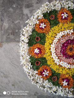 an overhead view of a flower arrangement on the ground with white, yellow and red flowers